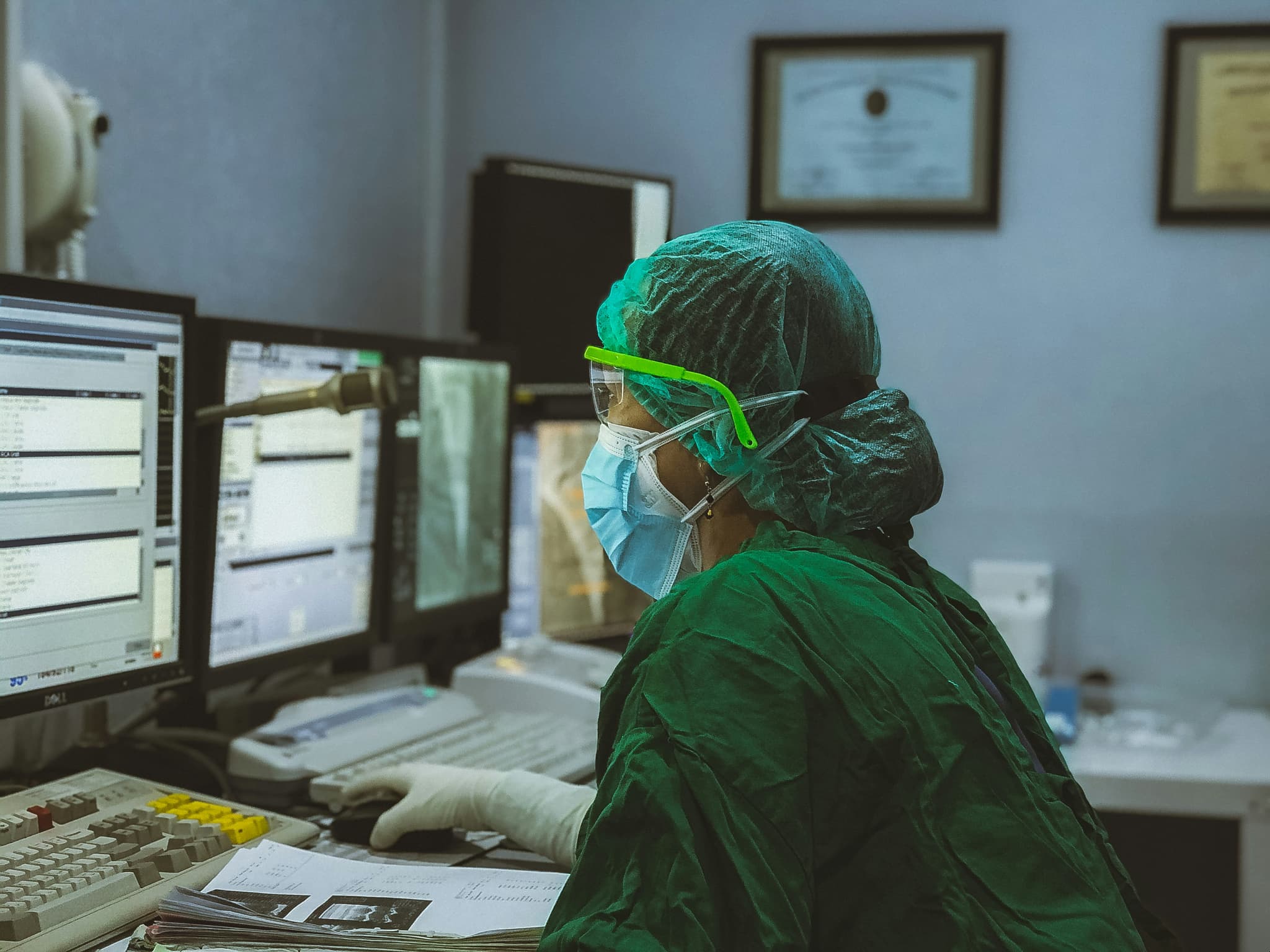 Clinician managing digital medical systems at workstation